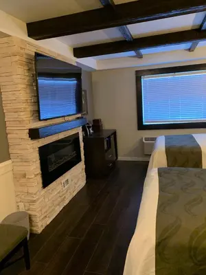 a bedroom with a fireplace and a bed in a room at Cedar Stables Inn & Suites in Sandusky