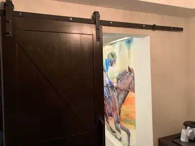 a painting of a horse next to a door at Cedar Stables Inn & Suites in Sandusky