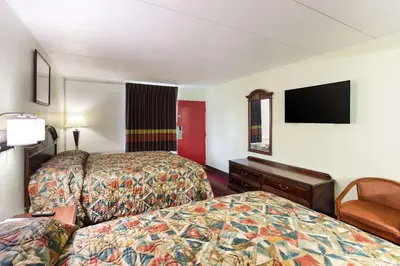 a hotel room with two beds and a flat screen tv at Rodeway Inn South Point in South Point
