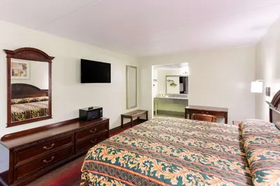a hotel room with a bed and a mirror at Rodeway Inn South Point in South Point