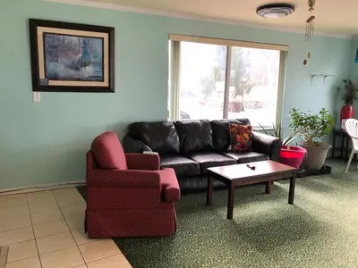a living room with a couch and a chair and a table at Rodeway Inn South Point in South Point