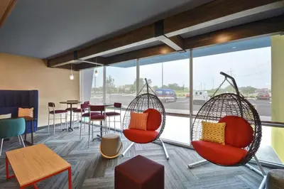 a room with chairs and a table and a window at Tru By Hilton Beavercreek Dayton in Fairborn