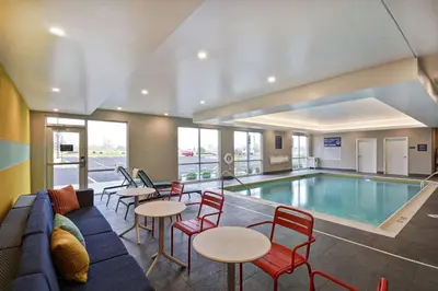 a pool room with a couch and tables and chairs at Tru By Hilton Beavercreek Dayton in Fairborn
