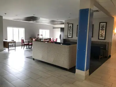 a lobby with a restaurant with tables and chairs at Holiday Inn Express - Toledo West - Napoleon by IHG in Napoleon