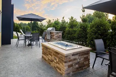 a patio with a grill and chairs and an umbrella at Fairfield Inn & Suites by Marriott Indianapolis Greenfield in Greenfield