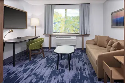 a living room with a couch and a desk at Fairfield Inn & Suites by Marriott Indianapolis Greenfield in Greenfield