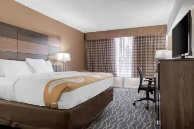 a hotel room with a large bed and a desk at Quality Inn and Conference Center in Richmond
