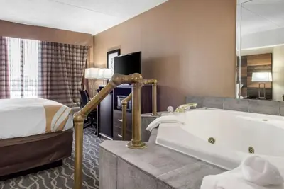 a hotel room with a tub and a bed at Quality Inn and Conference Center in Richmond