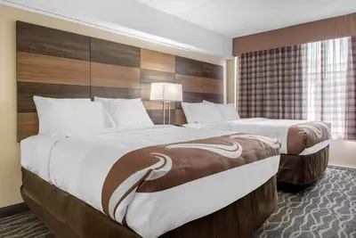 a large hotel room with two beds and a window at Quality Inn and Conference Center in Richmond