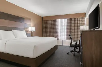 a bedroom with a bed and a desk and a television at Quality Inn and Conference Center in Richmond
