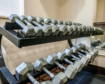 a bunch of dumbbells on a rack in a gym at Baymont by Wyndham Richmond I-70 in Richmond
