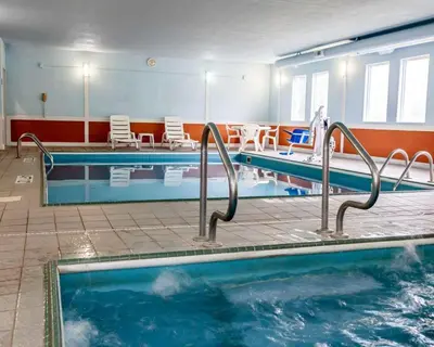 a large swimming pool with two lanes and chairs at Baymont by Wyndham Richmond I-70 in Richmond