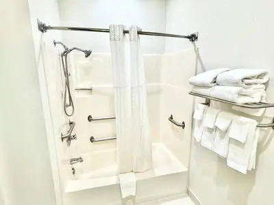 a bathroom with a shower and white towels at Baymont by Wyndham Richmond I-70 in Richmond