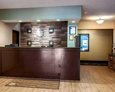 a hotel lobby with a large wooden reception desk at Baymont by Wyndham Richmond I-70 in Richmond