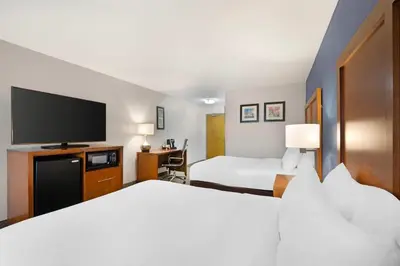 a hotel room with two beds and a flat screen tv at Comfort Inn & Suites North Greenfield in Greenfield
