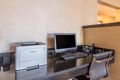a desk with a computer and a keyboard and monitor at Comfort Suites Fort Wayne North in Fort Wayne
