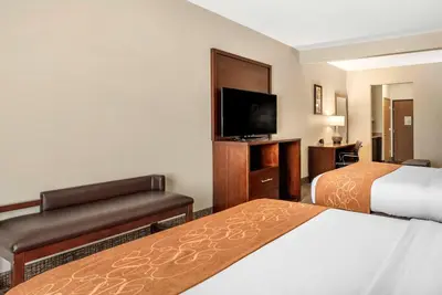 a hotel room with two beds and a flat screen tv at Comfort Suites Auburn near I-69 in Auburn