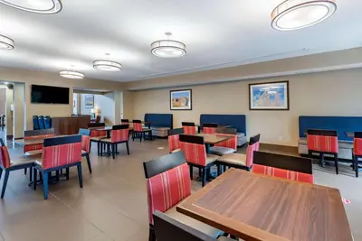 a dining room with tables and chairs in a restaurant at Comfort Suites Auburn near I-69 in Auburn