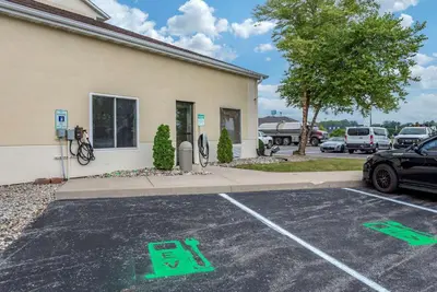 a parking lot with green arrows on the ground in front of a building at Comfort Suites Auburn near I-69 in Auburn