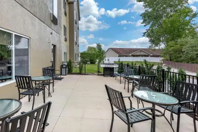 a patio with tables and chairs and a grill at Comfort Suites Auburn near I-69 in Auburn