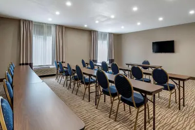 a conference room with tables and chairs and a flat screen tv at Comfort Suites Auburn near I-69 in Auburn