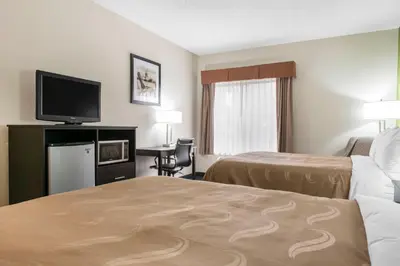 a hotel room with two beds and a flat screen tv at Quality Inn & Suites Anderson I-69 in Anderson
