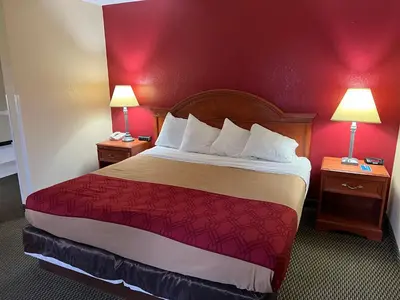 a hotel room with a large bed with red walls at Express Inn & suites in Decatur