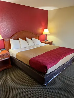 a large bed in a hotel room with red walls at Express Inn & suites in Decatur