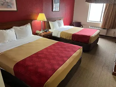 two beds in a hotel room with red walls at Express Inn & suites in Decatur