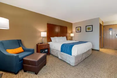 a hotel room with a bed and a chair at Comfort Inn Anderson South in Anderson