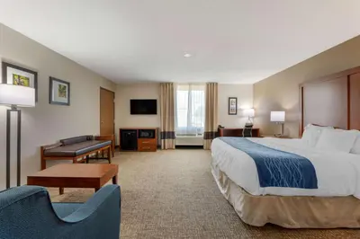 a hotel room with a large bed and a desk at Comfort Inn Anderson South in Anderson