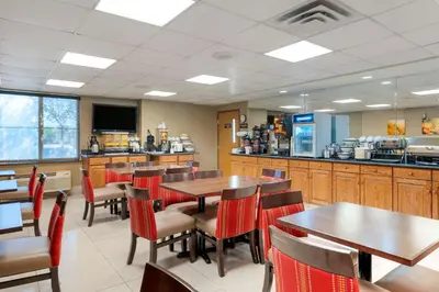 a restaurant with tables and chairs and a kitchen at Comfort Inn Anderson South in Anderson