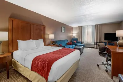 a hotel room with a large bed and a desk at Comfort Inn & Suites Lawrenceburg in Lawrenceburg