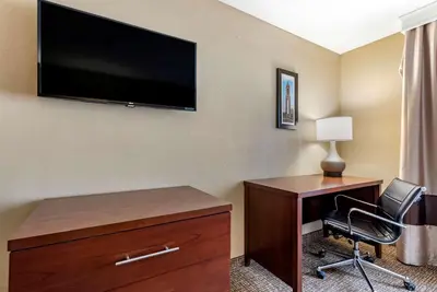 a hotel room with a desk and a flat screen tv at Comfort Inn & Suites Muncie Near University in Muncie