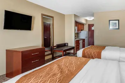 a hotel room with two beds and a flat screen tv at Comfort Inn & Suites Muncie Near University in Muncie