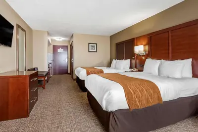 a hotel room with two beds and a desk at Comfort Inn & Suites Muncie Near University in Muncie