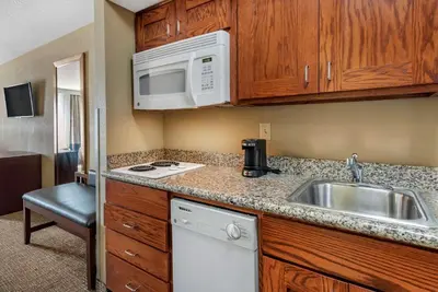 a small kitchen with a sink and a microwave at Comfort Inn & Suites Muncie Near University in Muncie