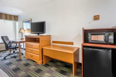 a hotel room with a desk and a microwave at Quality Inn & Suites Near Amish Country in Rushville