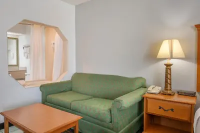 a living room with a green couch and a table at Quality Inn & Suites Near Amish Country in Rushville