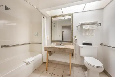 a bathroom with a toilet and a sink and a tub at Quality Inn & Suites Near Amish Country in Rushville