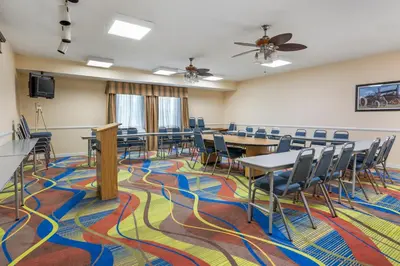 a conference room with tables and chairs on a colorful carpet at Quality Inn & Suites Near Amish Country in Rushville