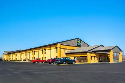 a yellow building with cars parked in a parking lot at Quality Inn & Suites Greensburg I-74 in Greensburg