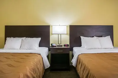 a hotel room with two beds and a lamp at Quality Inn & Suites Greensburg I-74 in Greensburg