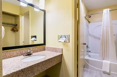 a bathroom with a sink and a tub and a mirror at Quality Inn & Suites Greensburg I-74 in Greensburg