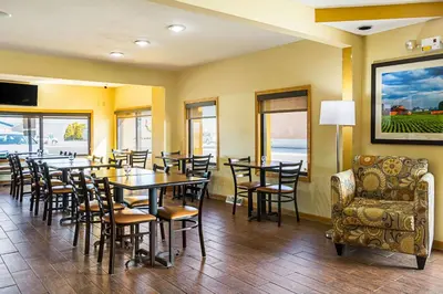 a dining room with tables and chairs and windows at Quality Inn & Suites Greensburg I-74 in Greensburg
