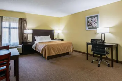 a hotel room with a bed and a desk and a chair at Quality Inn & Suites Greensburg I-74 in Greensburg
