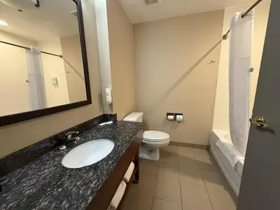 a bathroom with a sink and a toilet and a mirror at SureStay by Best Western Marion in Marion