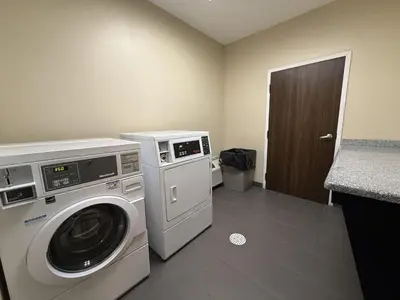 a laundry room with a washing machine and a washer at SureStay by Best Western Marion in Marion