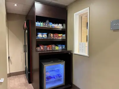 a refrigerator in a room with a shelf with food at SureStay by Best Western Marion in Marion