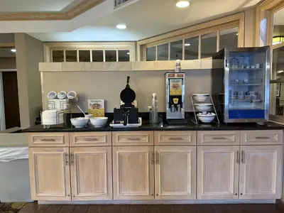 a kitchen with wooden cabinets and a counter top at SureStay by Best Western Marion in Marion